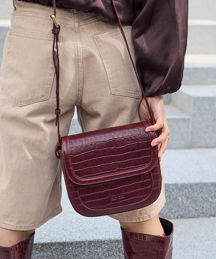 Nina schoudertas in chocoladebruin leer met flap en verstelbare riem.