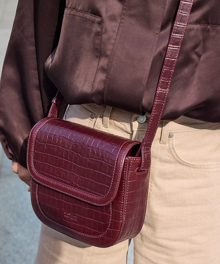 Nina schoudertas in chocoladebruin leer met flap en verstelbare riem.