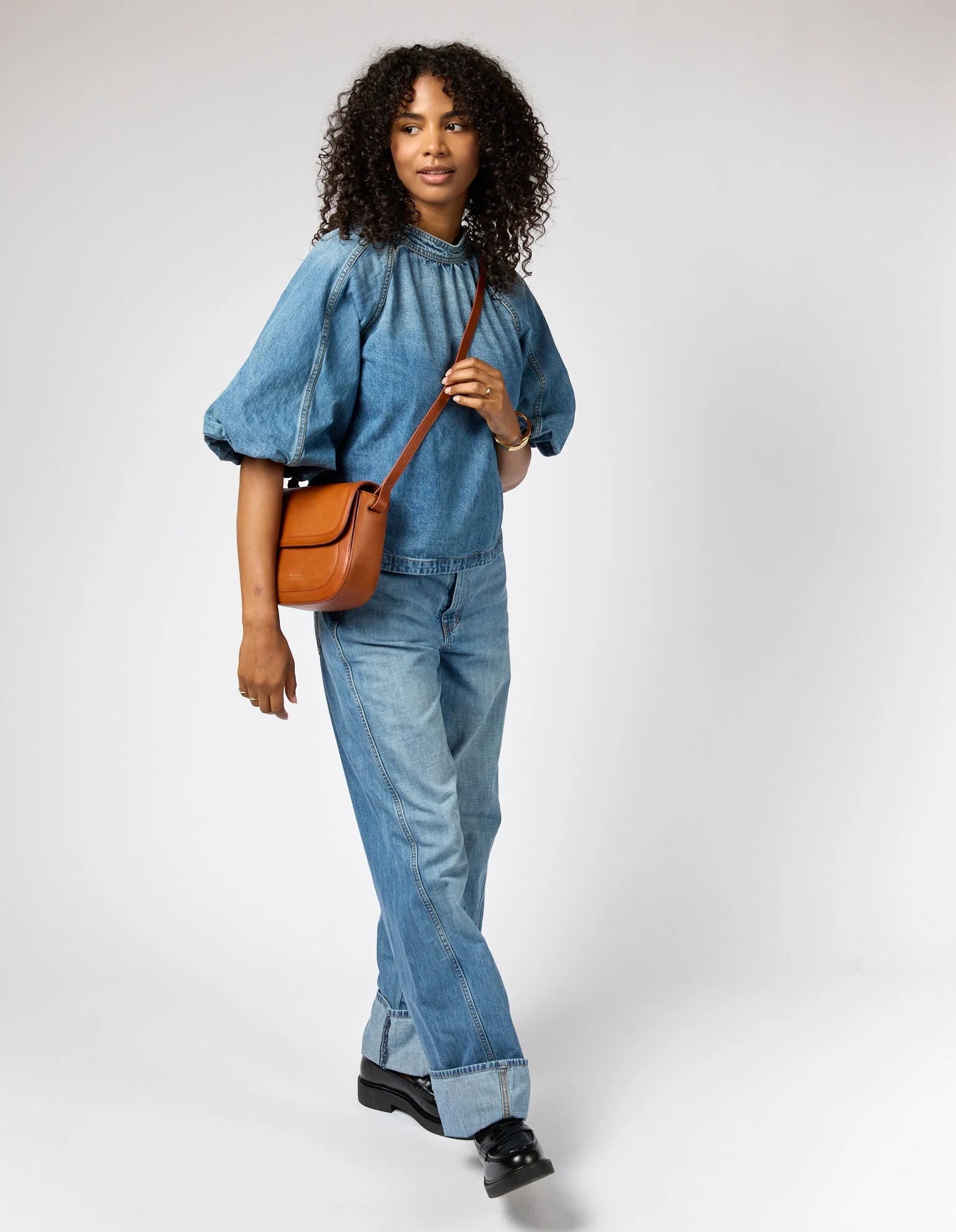 Nina schoudertas in chocoladebruin leer met flap en verstelbare riem.