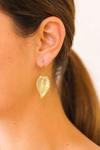 Oorbelletjes in een glazen koker met gouden glitters.